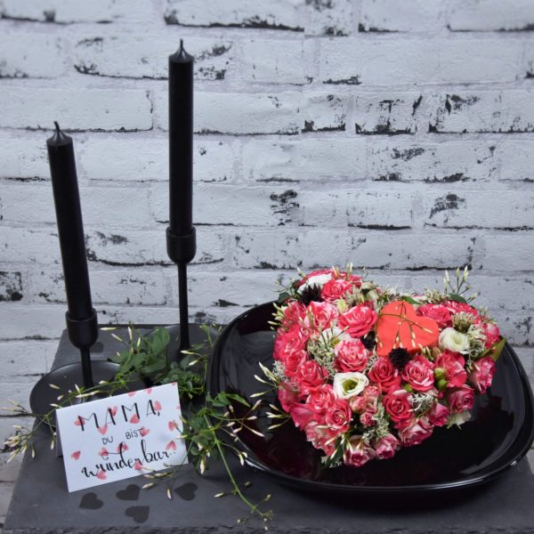 Muttertag Der Blütenwald rosa geschmücktes florales HerzSchwarzer Tisch mit schwarzen Kerzen
